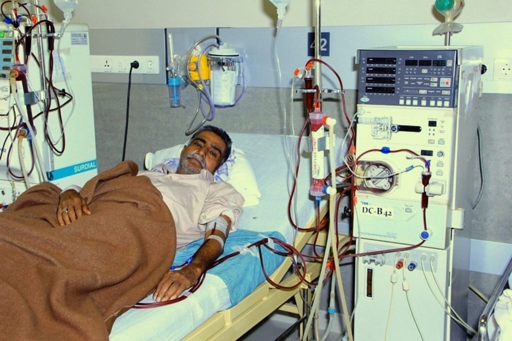 shows a dialysis patient along with a dialysis machine